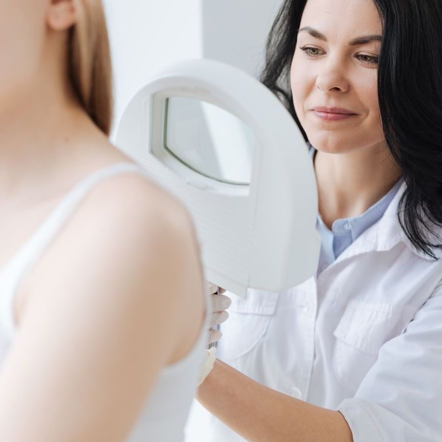 Ärztin untersucht den Rücken einer Frau